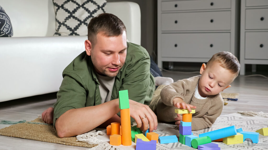 sitly-babysitter-building-tower-using-colorful-wooden-blocks-with-boy