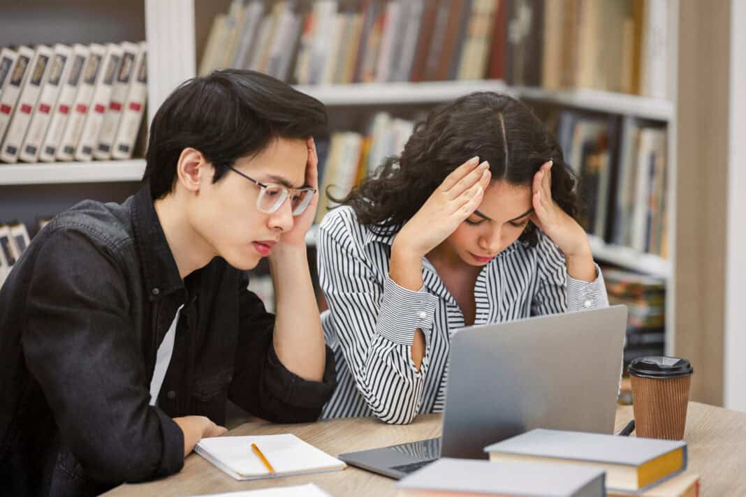 photo-of-two-stressed-international-students-in-library