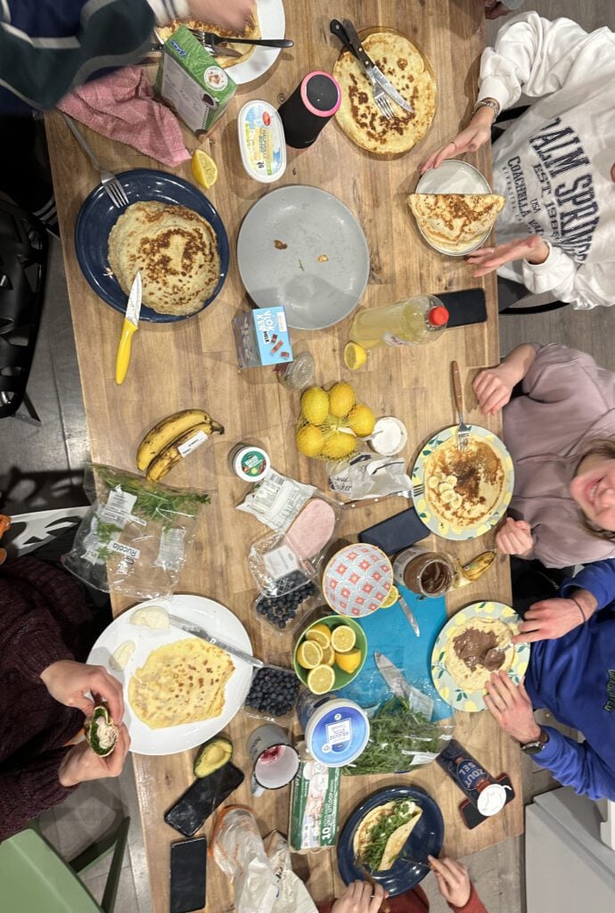 photo-of-table-full-of-food-as-students-prepare-pancakes-together