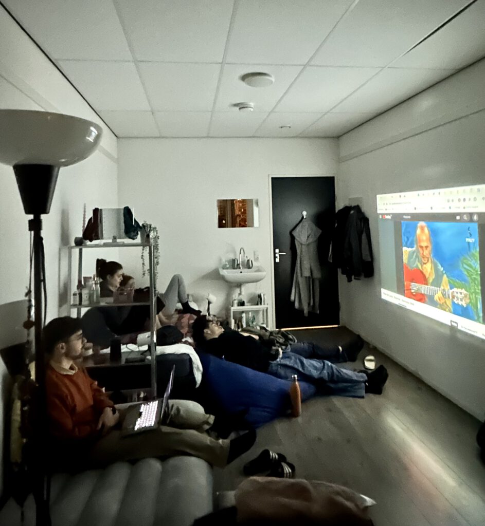 photo-of-a-group-of-students-watching-something-on-a-projector-in-a-student-room