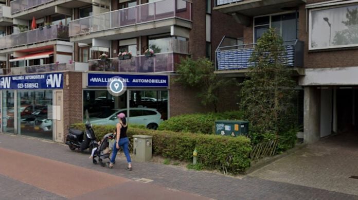 screenshot-of-street-view-of-haarlem-apartment-with-greenery-in-front-auto-sales-in-background-and-woman-pushing-stroller