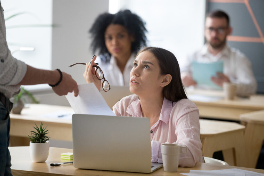 photo-of-woman-looking-frustrated-looking-up-at-someone-while-being-handed-summary-dismissal-papers-in-the-Netherlands