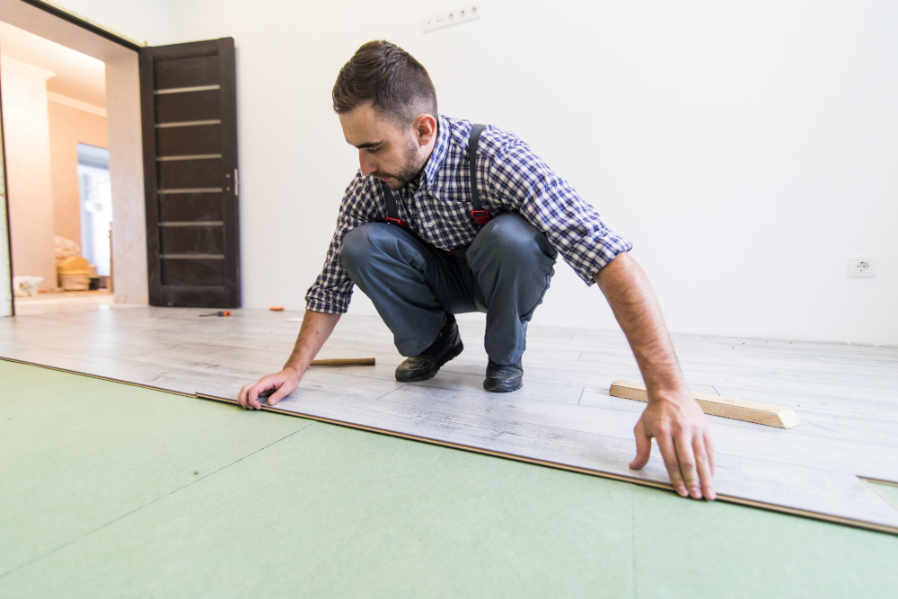photo-of-man-laying-down-flooring-in-rental-with-no-flooring