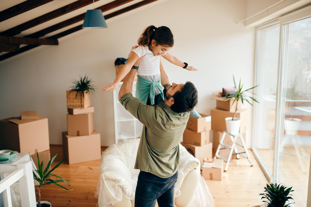 photo-of-father-holding-daughter-above-head-in-new-apartment