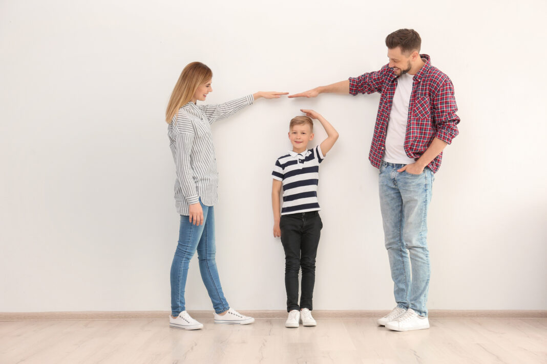 photo-of-tall-parents-measuring-their-child