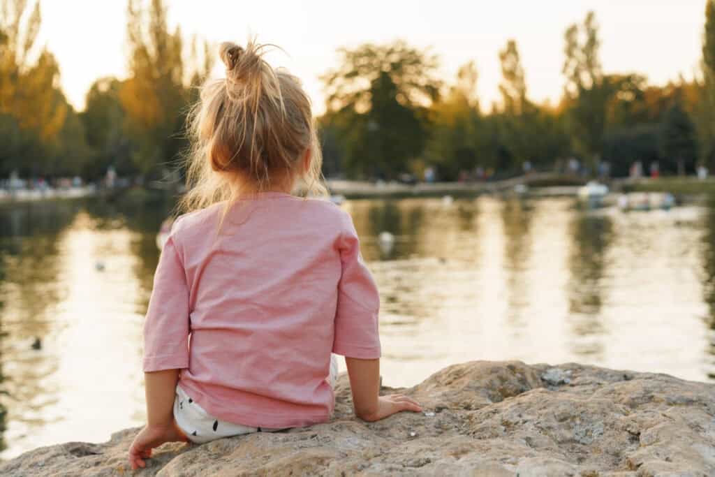 photo-of-little-girl-sitting-in-front-of-lake-in-the-Netherlands