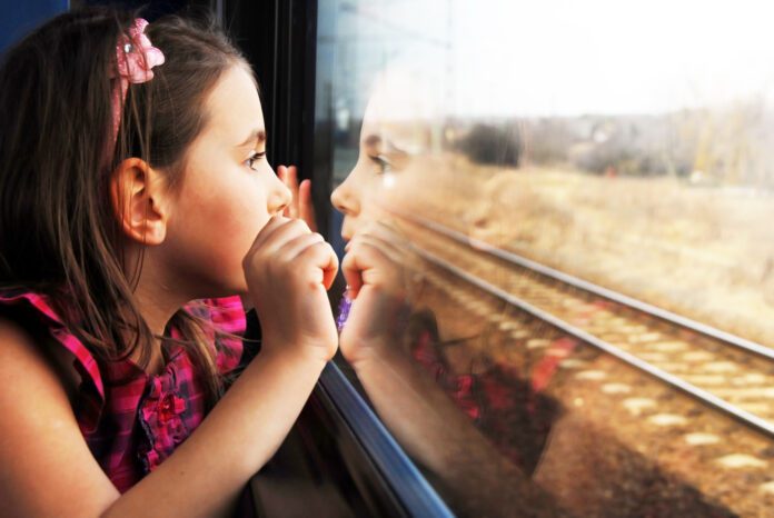photo-of-little-girl-staring-out-train-window