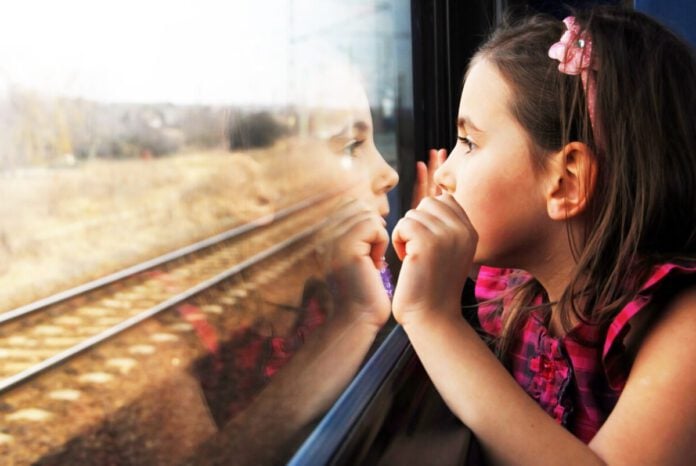 photo-of-little-girl-staring-out-train-window