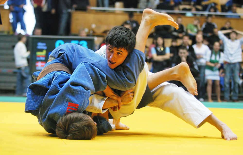 two-boys-on-mat-tackling-in-judo-competition