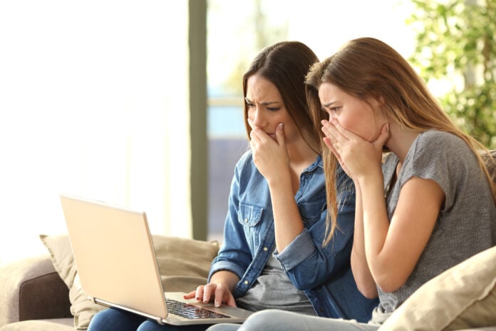 two-girls-staring-at-a-laptop-screen-in-disgust