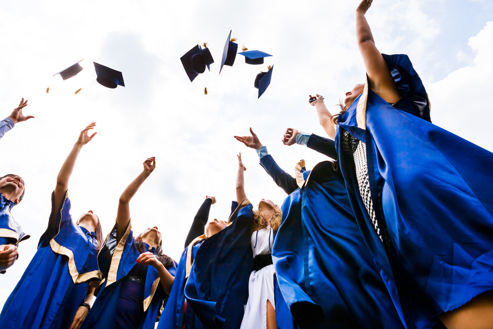 Group-of-young-gradutes-throw-their-graduate-caps-in-the-air