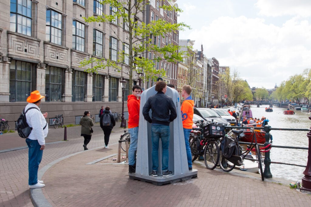 photo-of-four-men-using-outdoor-public-urinal-amsterdam