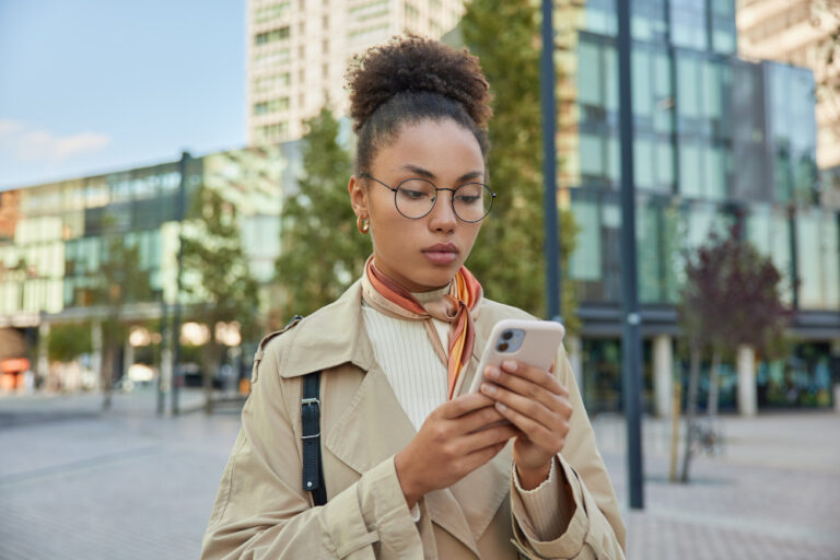 photo-of-woman-looking-at-phone-using-online-savings-platform-raisin-while-living-in-Netherlands