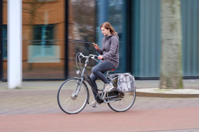 girl-using-her-phone-while-cycling-in-the-netherlands