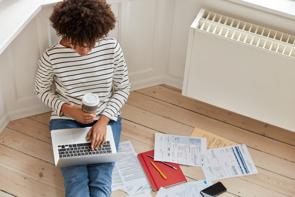 photo-of-woman-sitting-on-floor-going-through-utilities-checklist-while-moving-house-in-the-Netherlands