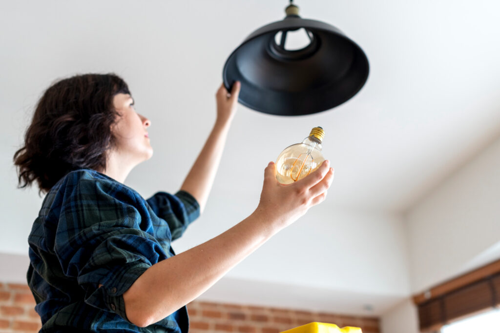 photo-of-woman-holding-lightbulb-installing-lightbulb-while-moving-house-in-the-Netherlands-after-setting-up-utilities