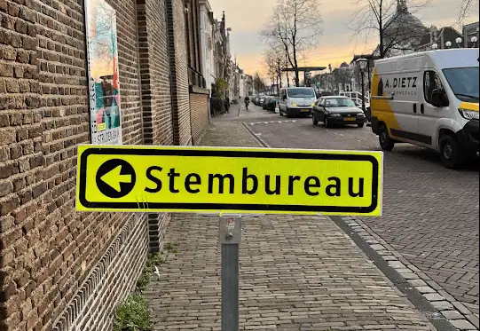 neon-yellow-sign-directing-where-the-dutch-municipal-election-voting-location-is-leiden