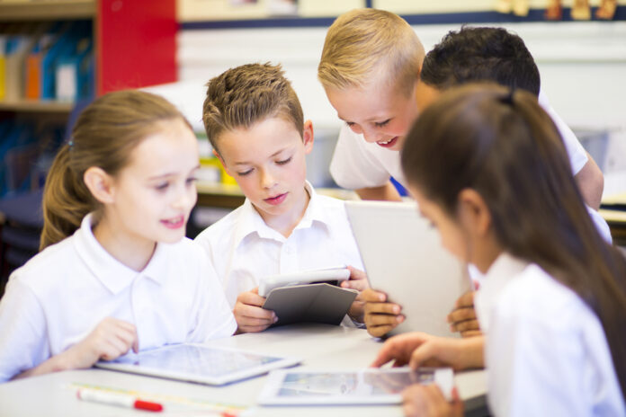 children-wearing-school-uniforms-working-with-tablets-in-international-classroom
