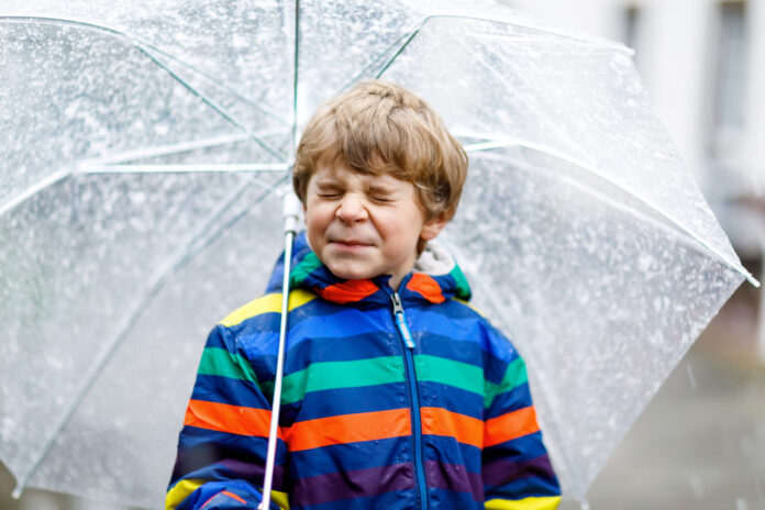 cute-child-holding-umbrella-shielsing-from-snowfall