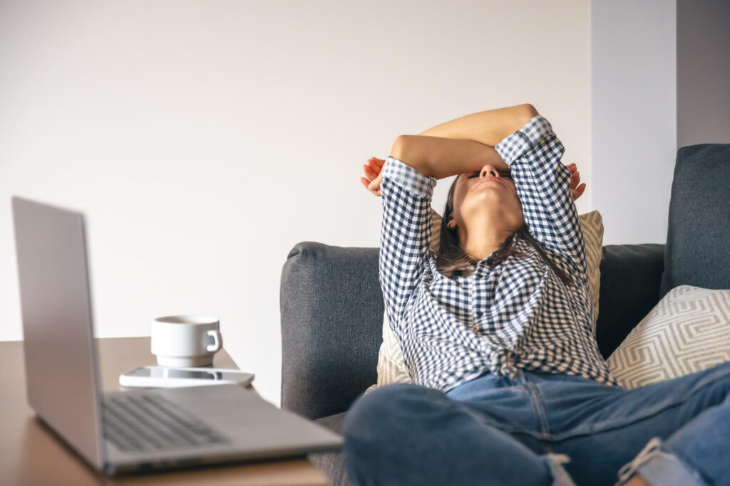 photo-of-international-woman-lying-on-couch-dealing-with-workplace-burnout-in-the-Netherlands