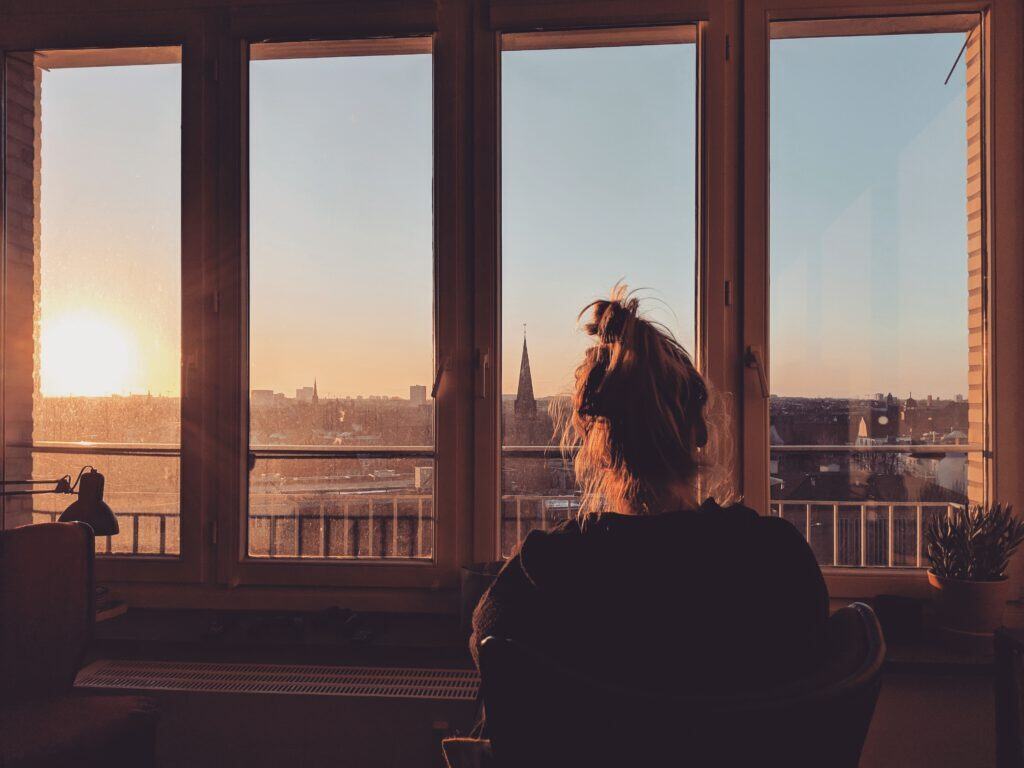 photo-of-woman-looking-out-of-window-thinking-about-which-type-of-insurance-in-the-Netherlands-she-should-take-out