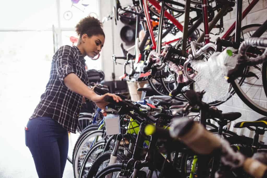 foto de uma mulher olhando para bicicletas e considerando o que ela precisa enquanto compra uma bicicleta em uma loja de bicicletas na Holanda