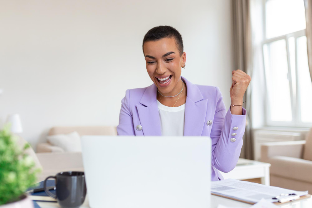 Photo-of-woman-celebrating-looking-at-computer-because-her-Dutch-mortgage-interest-is-tax-deductible