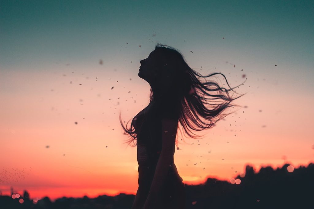 A girl practicing uitwaaien with her hair blowing in the wind