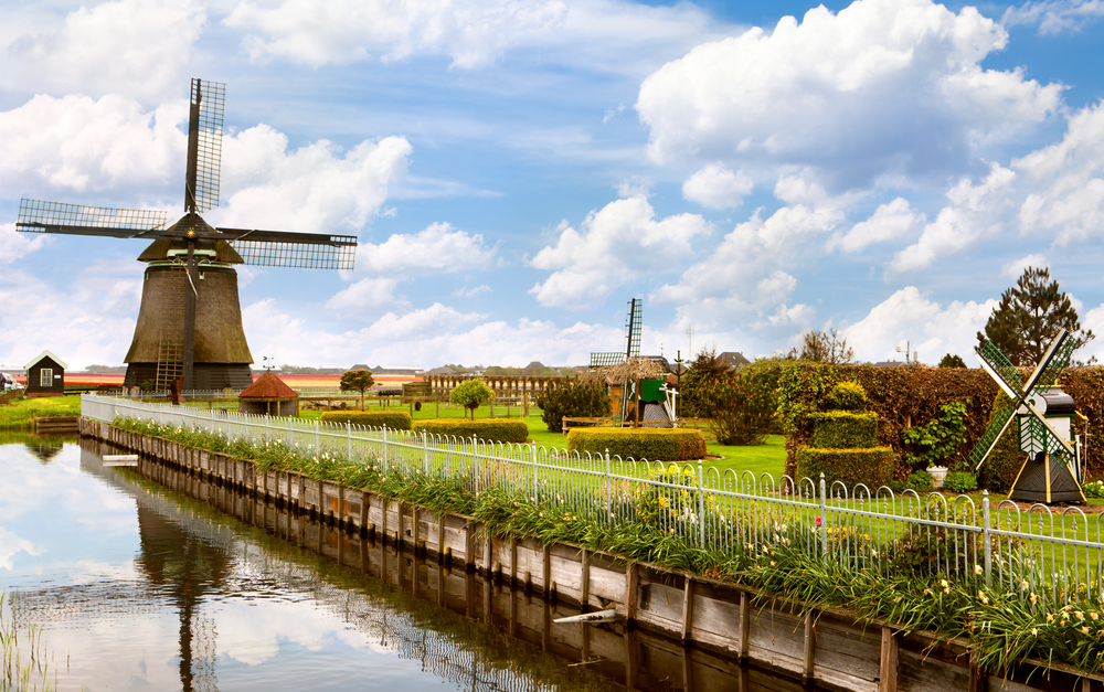 windmill-near-canal-netherlands-with-miniature-windmills-in-garden