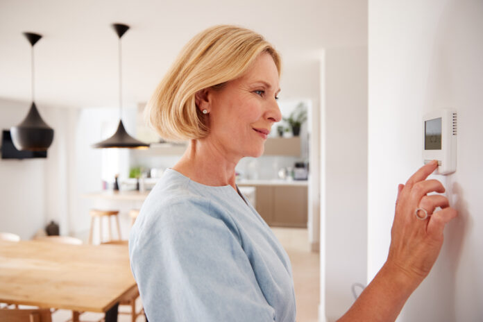 woman-adjusting-thermostat-in-her-dutch-home-with-a-new-energy-contract