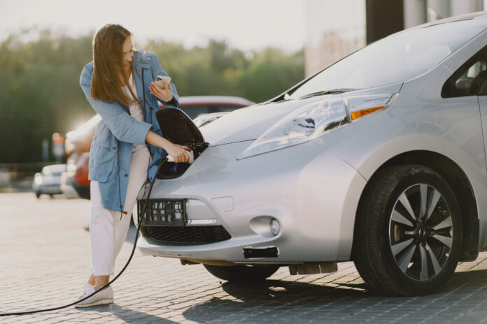 photo-of-woman-charging-electric-car