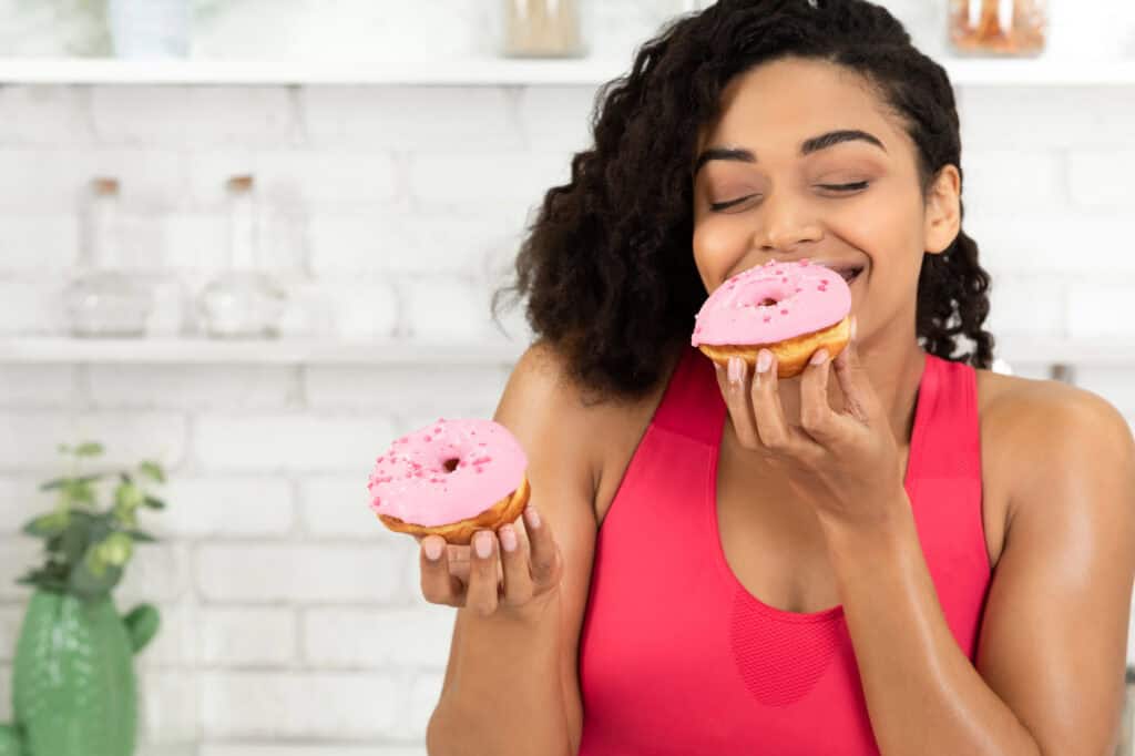 photo-of-woman-eating-doughnuts-birthday-freebies-in-the-netherlands