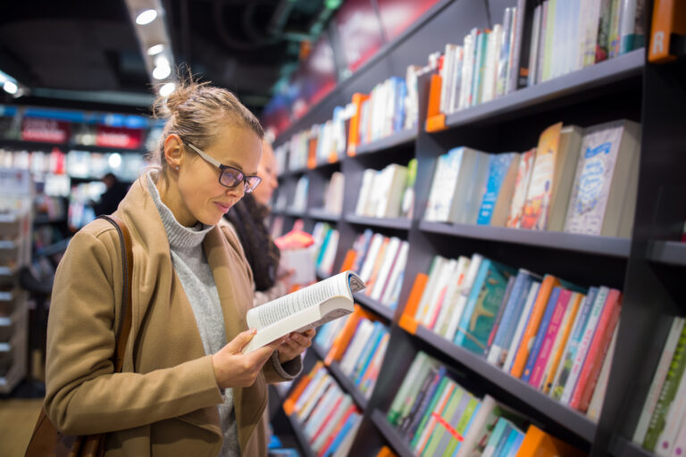Young-female-checking-out-a-book-in-a-bookstore