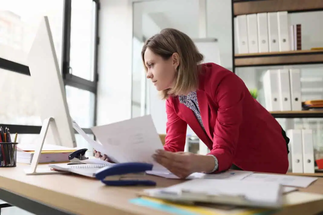 woman-in-office-looking-at-paperwork-she-needs-to-fully-set-up-dutch-business-and-pay-taxes