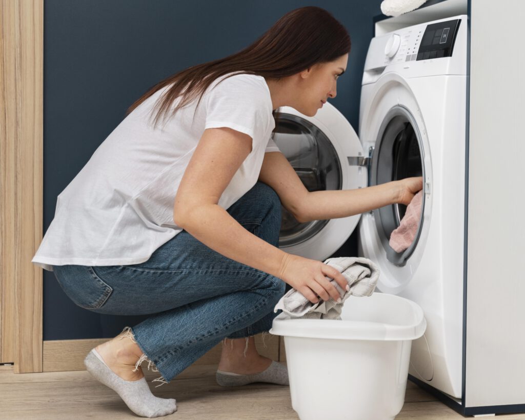 woman-putting-dirty-clothes-in-washing-machine-during-off-peak-times-to-save-money-in-the-netherlands