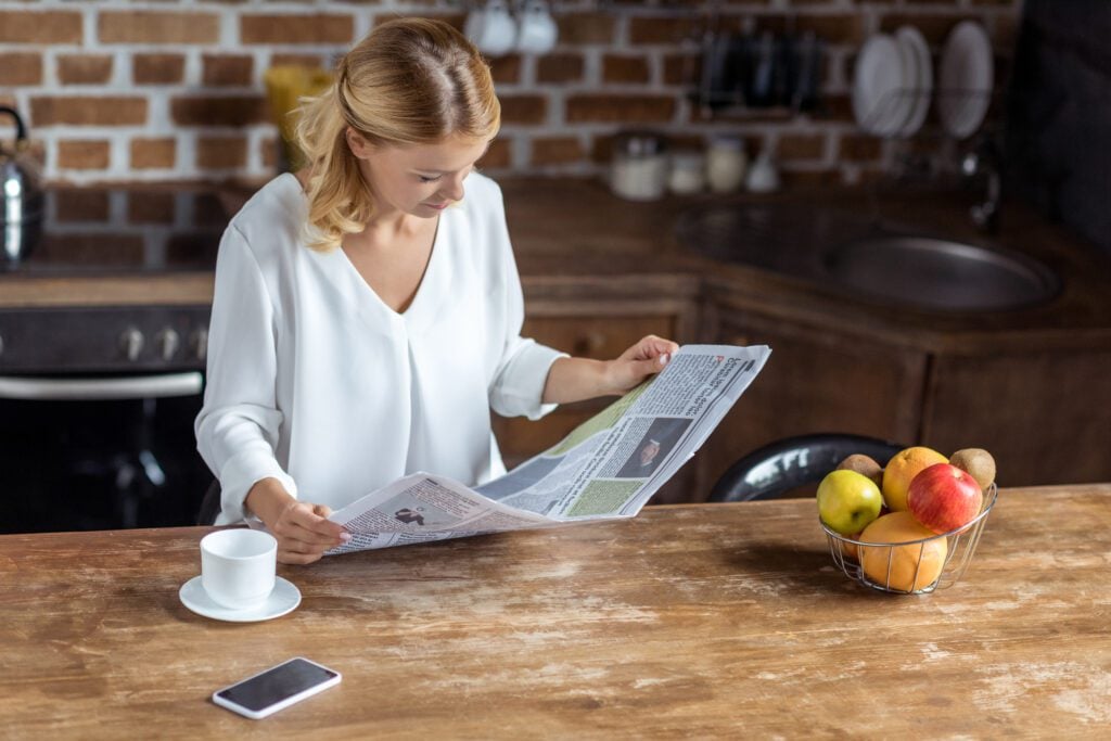 woman-reading-dutch-news-in-english-in-newspaper