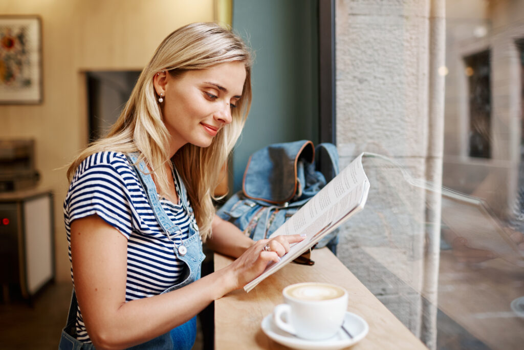 woman-reading-her-work-or-study-material-in-a-cafe-in-groningen-with-a-mug-of-coffee-next-to-her