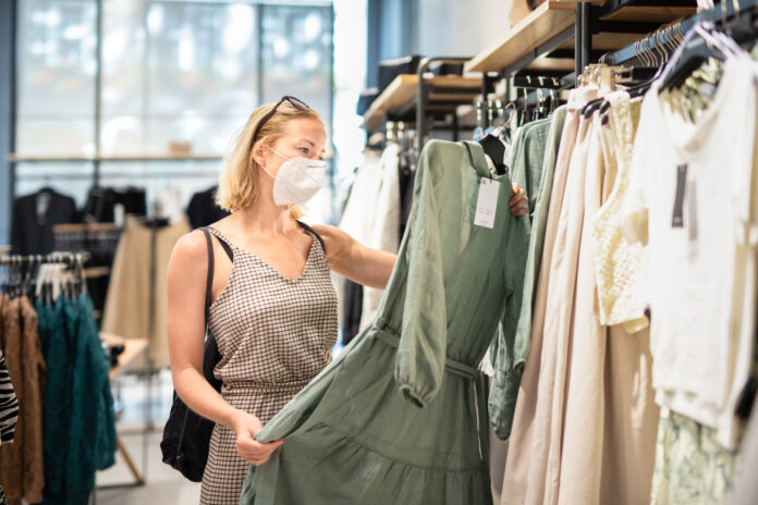Woman-shopping-in-a-dutch-clothing-store-wearing-a-mask