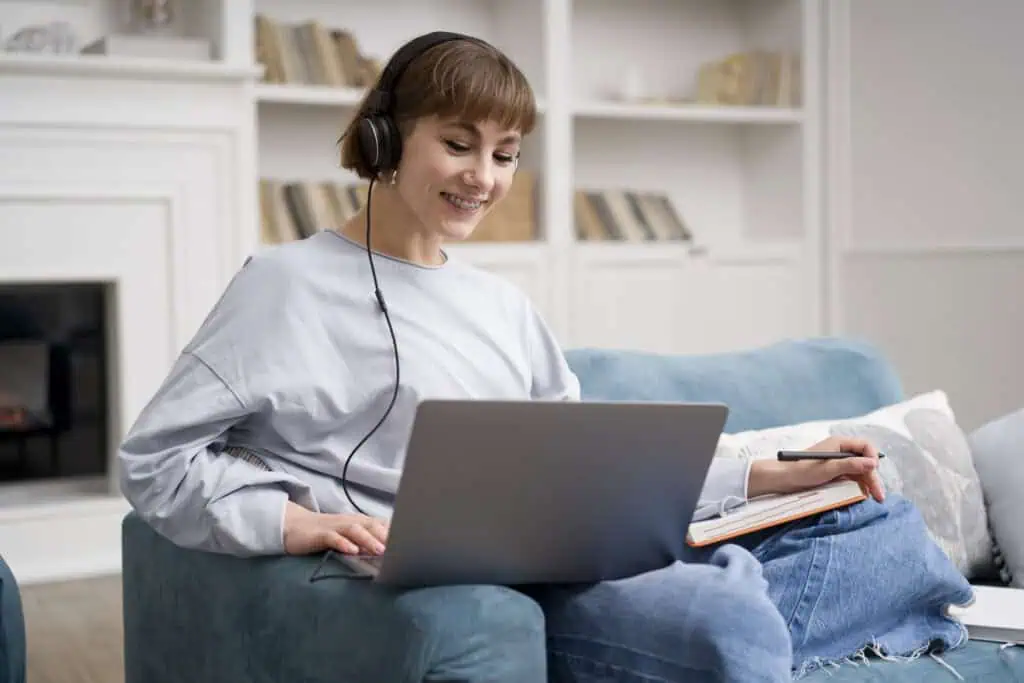 photo-of-woman-taking-online-dutch-course-sitting-on-couch-with-laptop-and-headphone