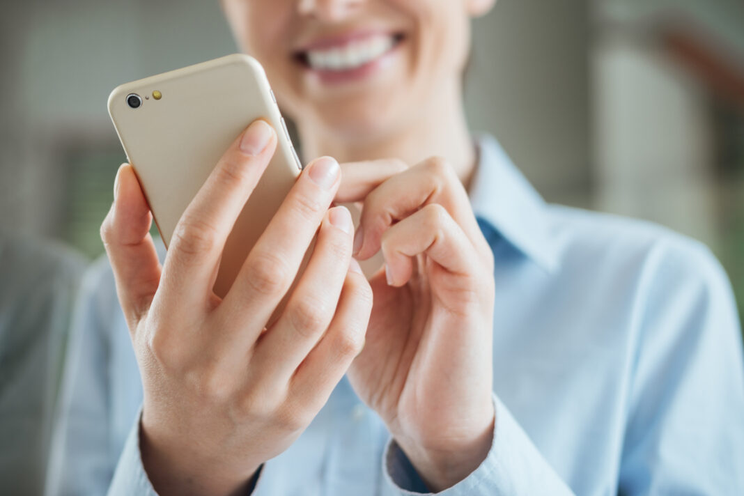 woman-smiling-using-her-phone