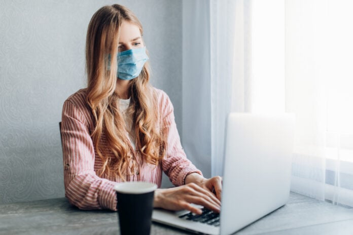 woman-working-on-laptop-wearing-mask