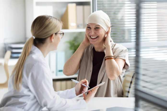photo of a woman with cancer smiling at doctor after being told she is cancer free