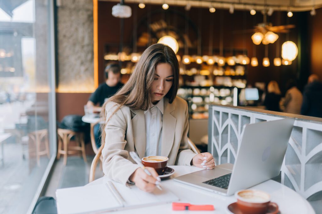 picture-of-a-young-woman-with-Dutch-health-insurance-sitting-at-a-cafe-and-working