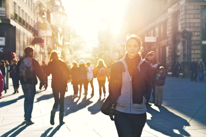 woman-standing-on-crowded-city-street-in-sun