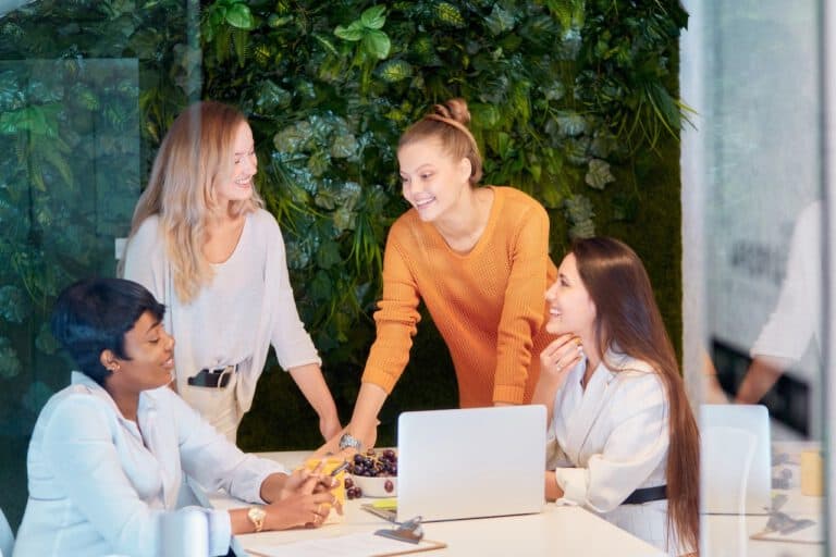 photo-of-diverse-colleagues-in-netherlands-discussing-over-a-laptop-with-green-vertical-garden-in-background