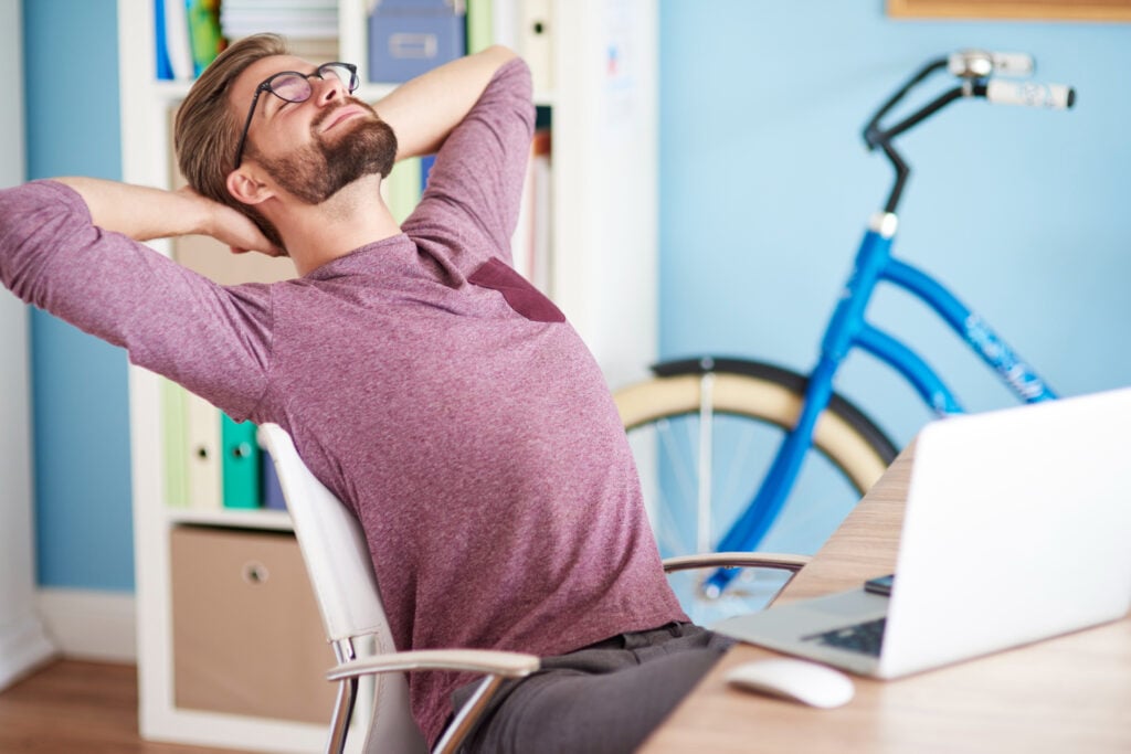 photo-of-man-with-sponsored-job-relaxing-in-office-with-bike-in-background
