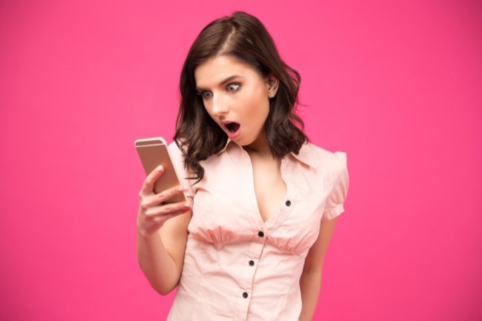 woman-staring-at-phone-open-mouthed-with-shock