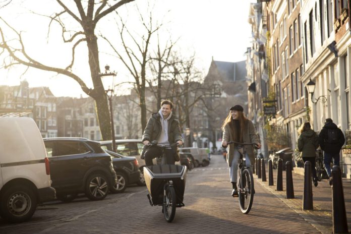 young-adults-biking-in-amsterdam-with-bike-insurance-in-the-netherlands