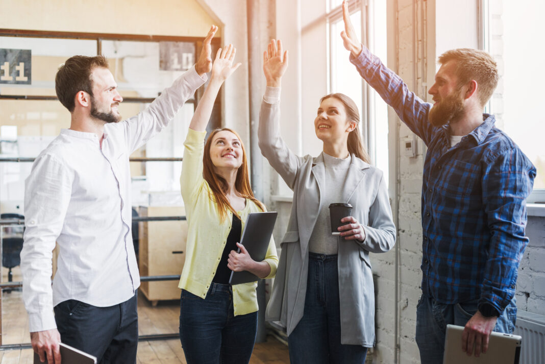 photo-of-colleagues-high-fiving-at-work