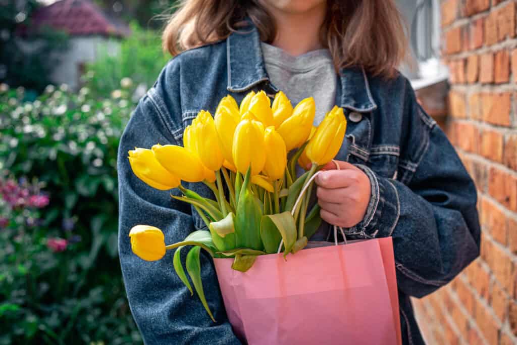 jovem segurando um buquê de tulipas que ganhou de graça no dia nacional das tulipas na Holanda